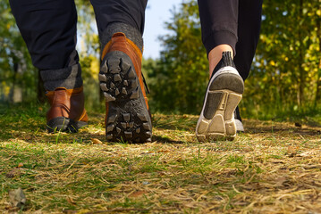 Man hiking in the woods in Autumn pine forest. Men boots walking in the woods on sunny day. hiking concept, outdoor lifestyle.