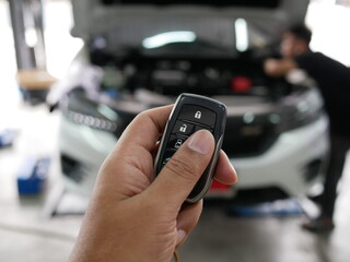 closeup of hand pressing on the remote control system of modern car.