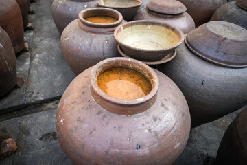 Naklejka premium Jars of processing soybean jam made by traditional outdoor way under natural sunlight