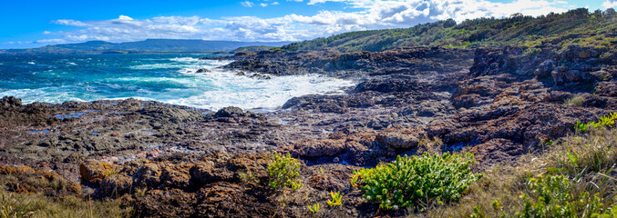 Panorama view from Bass Point Reserve across Pacific Ocean to Mystics Beach on Minnamurra and spit with Saddleback Mountain in distance,  Shellharbour, New South Wales Australia