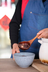 The Chinese are scooping the boiled Laba porridge into a bowl - obrazy, fototapety, plakaty