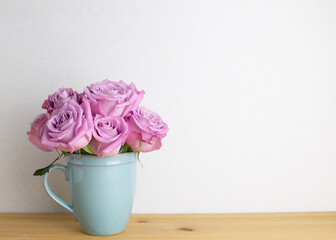 Home interior. Bunch of purple rose flowers on wooden table with white background. floral arrangement, copy space