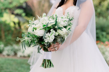 Bride wearing a Veil is Holding a Gorgeous Classic White and Green Bridal Bouquet