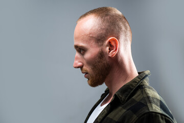 Studio shot of young man looking away. Profile face of handsome guy with confident face.