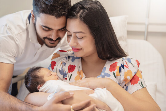 Asian parents with newborn baby, Closeup portrait of asian young couple father mother holding new born baby in hospital bed. Happy asia lovely family, nursery breastfeeding mother’s day concept
