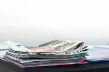 A stack of newspapers on the office table. Free space in the background for text. Latest news