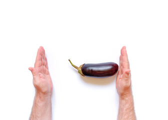Man's hand holds fresh ripe eggplant on a white background. Harvesting concept. An allegory on the size of male sex ogans. Size comparison. Images for the male doctor's office.