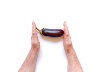 Man's hand holds fresh ripe eggplant on a white background. Harvesting concept. An allegory on the...
