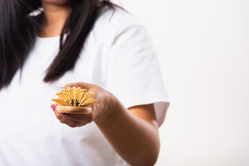 Woman weak hair she shows hairbrush with damaged long loss hair in the comb brush on hand