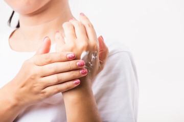 Woman applying lotion cosmetic moisturizer cream on her behind the palm skin hand
