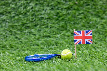 Tennis ball with Union Flag are on green grass 