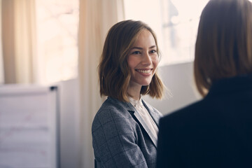 Portrait of beautiful businesswoman smiling at colleague