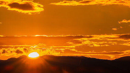 Widok na tym zdjęciu przedstawia przepiękny zachód słońca rzucający swoje ostatnie promienie .