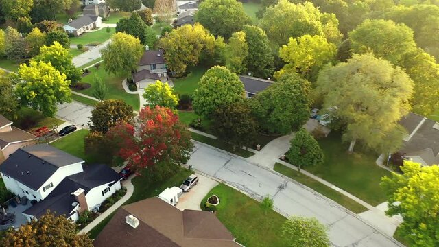 Aerial footage of  an American town  showing typical suburban housing estates with rows of houses, taken on a sunny day using a drone. Establishing shot of typical suburban neighborhood