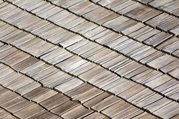 Elevated view of traditional wooden shingle roof with a few damaged shakes