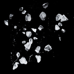 Flying ice cubes and drops isolated on black