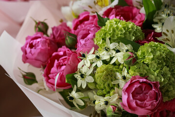 Pink-green bouquet of roses, white lilies, hydrangeas on a purple background