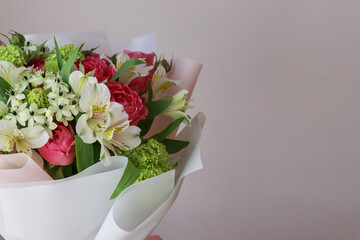 Pink-green bouquet of roses, white lilies, hydrangeas on a light background