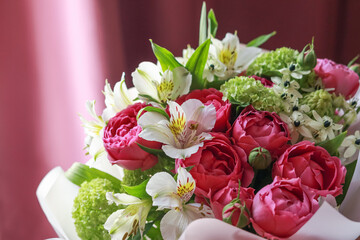 Pink-green bouquet of roses, white lilies, hydrangeas on a purple background