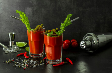 Tomato Bloody Mary ice cold drink with fresh celery, pickles, olives, and lime.