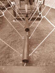the single-log bridge with rope at playground for kids making development of the concept of balance and equilibrium vintage photo