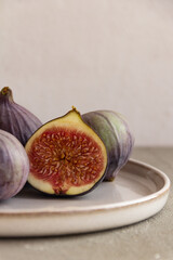 Fresh figs on a plate on a light concrete background