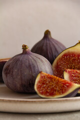 Fresh figs on a plate on a light concrete background