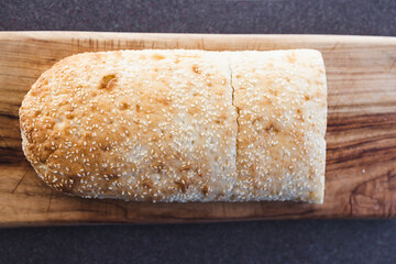 simple food ingredients, fresh turkish bread with sesame seeds on cutting board