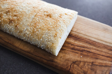 simple food ingredients, fresh turkish bread with sesame seeds on cutting board