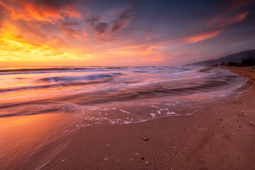 Amazing view with colorful reflections on the beach at sunrise
