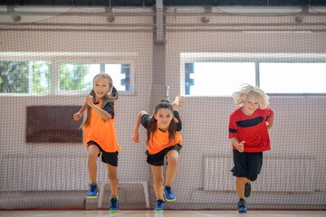 Kids in bright sportswear running in the gym