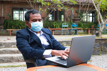 Young man wearing face mask is working during corona crisis.