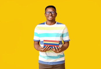 African-American man with books on color background