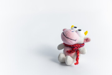 Children's soft toy bull in a red scarf sits on a white background. Toy for children's games. Symbol of the new 2021.
