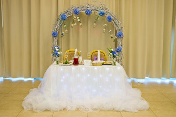 A table for newlyweds with a decorated arch installed in the banquet hall.