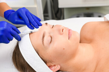 Obraz na płótnie Canvas Close up woman face during injection procedure
