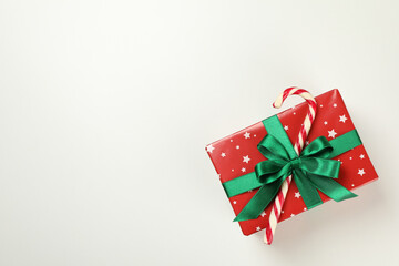 Christmas box with candy cane on white background