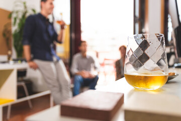 Three young architects discussing about business issues after the meeting inside the conference room in a fancy elegant office in Lisbon. Three business persons talking informally and drinking a beer