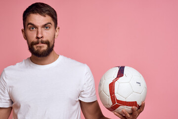Man with a soccer ball on a pink background energy gesticulate with his hands coach emotions model