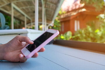 People hand using smartphone with blur cafe shop background.