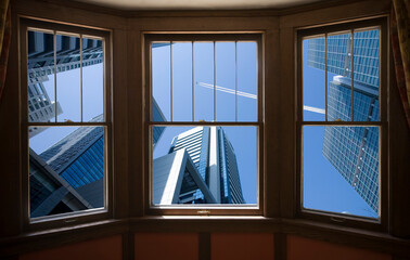 窓からビルと飛行機雲