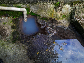 Water flow from a block drain pipe onto a ground, Ecology and environment protection concept