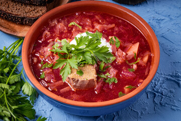 Borscht with sour cream in earthenware close-up - a dish of traditional Russian and Ukrainian cuisine