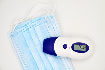 A non-contact infrared thermometer on the protective medical masks