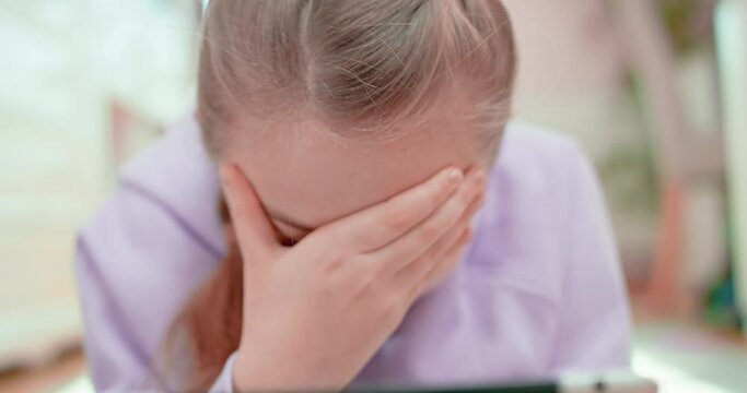 Teen girl facepalm lying on the floor in front of the tablet
