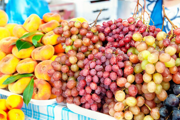 background of various grape varieties at the farmers ' market. the harvest of fruits and vegetables is on the counter of the farmers ' market