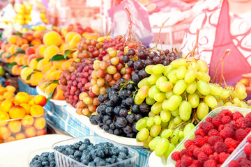 background of various grape varieties at the farmers ' market. the harvest of fruits and vegetables is on the counter of the farmers ' market