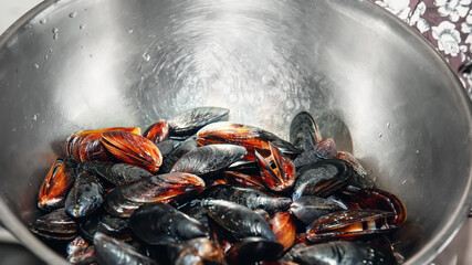 Fresh mussels in a metal bowl. Preparing for an outdoor seafood barbecue. Picnic of healthy food,...