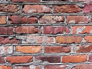 Obraz premium A mottled red brick wall