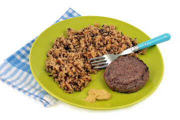 Steak haché de boeuf avec du riz pilaf et de la moutarde servis dans une assiette sur fond blanc